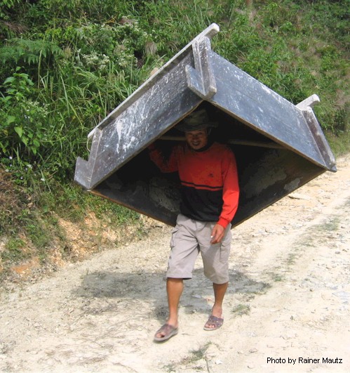 Farmer carrying a rice thasher vat