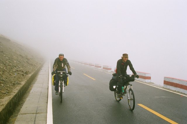 Next day after they acclimatised, up to the pass in the rain. Steve hat backwards, Brice hat forwards.